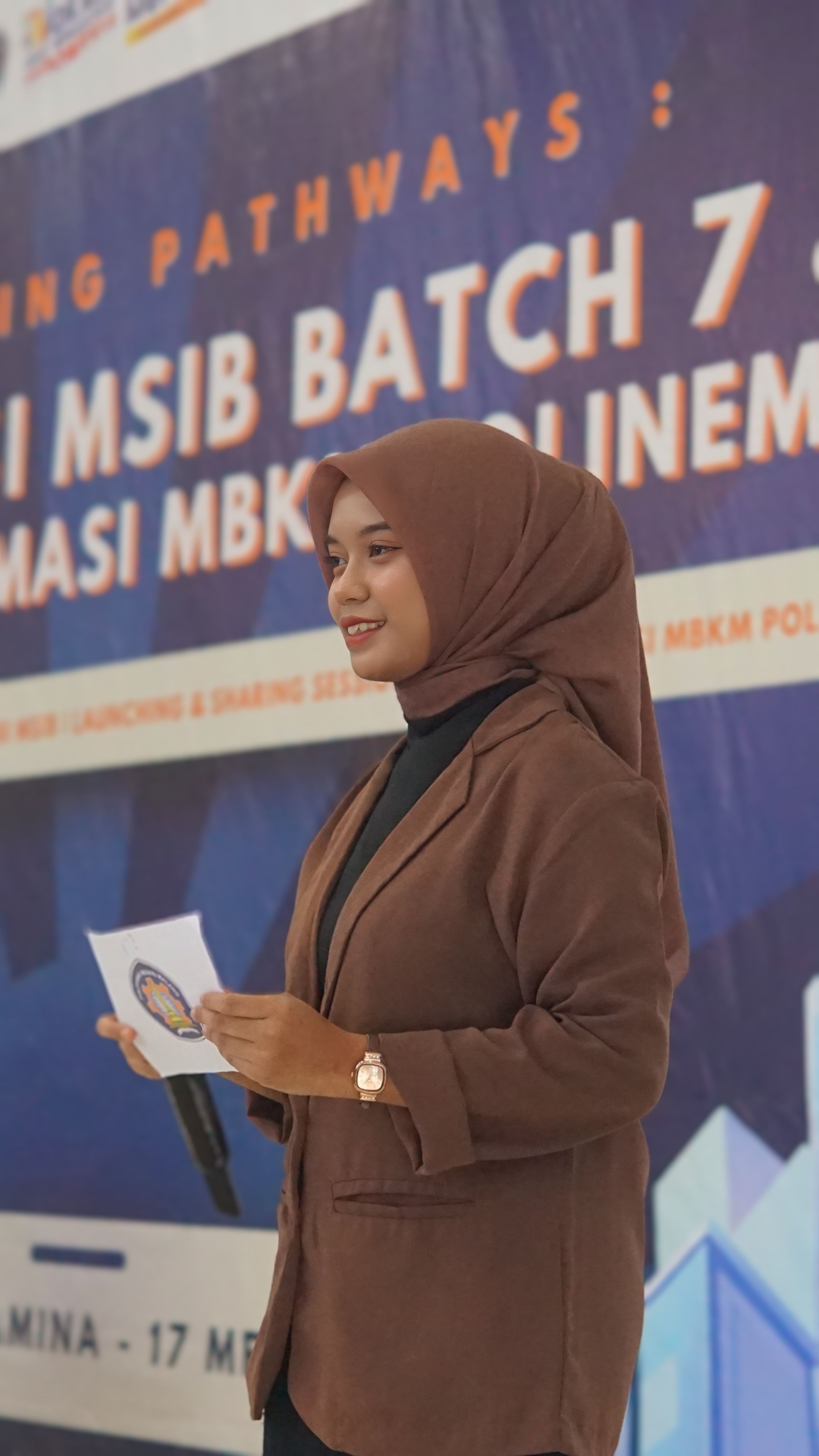 Nur Hidayati membawakan acara sambil memegang cue card dan mikrofon